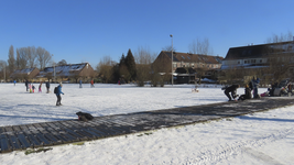 901323 Gezicht op de Meernse IJsbaan, met enkele schaatsers en spelende kinderen, in het Kloosterpark te De Meern ...